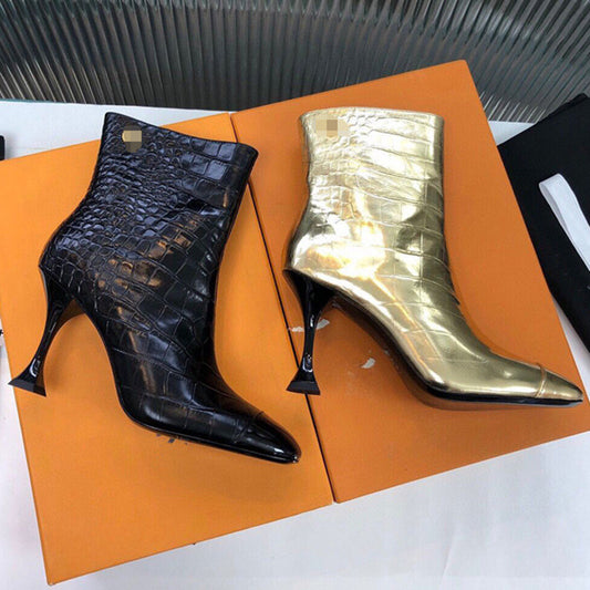 Black and gold high-heeled boots on an orange box