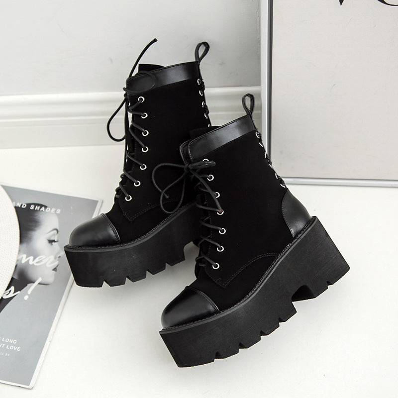Black platform boots on a white surface with a magazine in the background