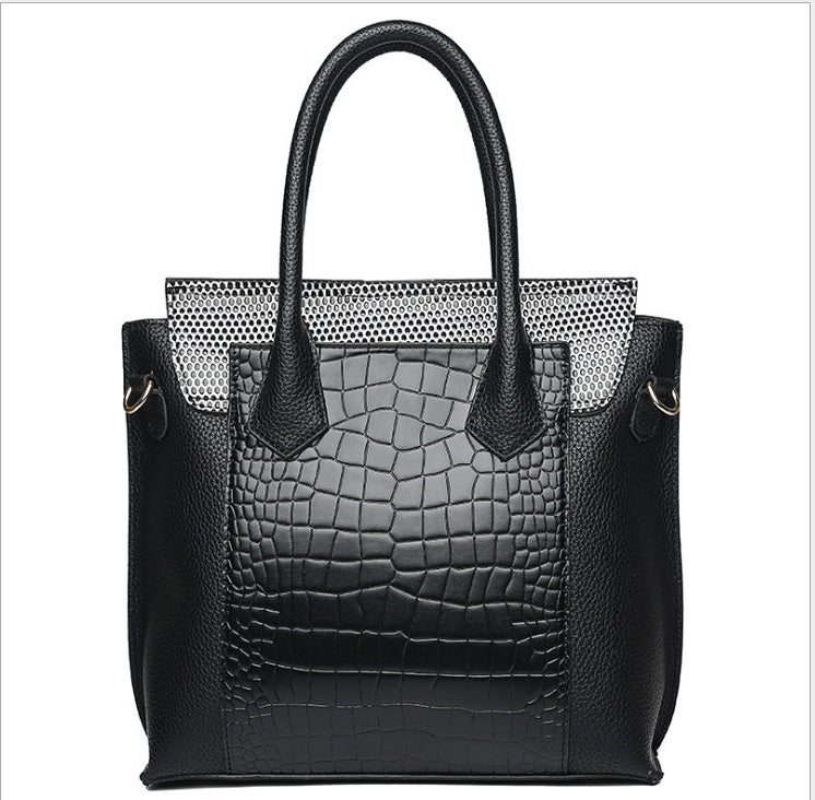 Black handbag with textured pattern on a white background