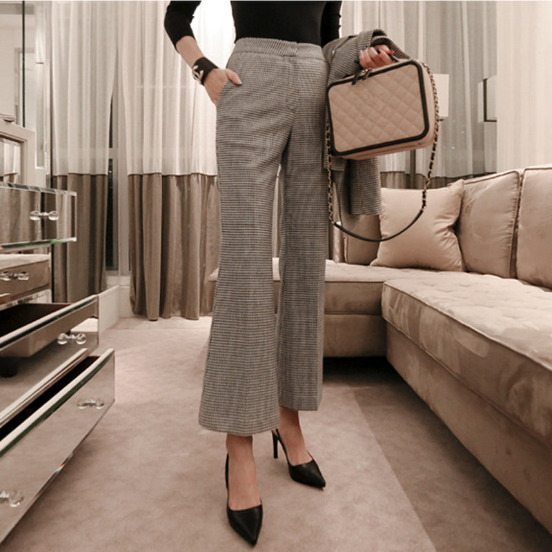 Person wearing gray checkered pants and black shoes in a living room setting. by millivan