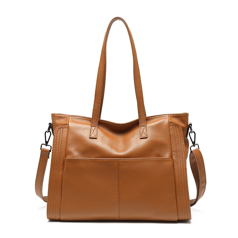 Brown leather tote bag with shoulder strap on a white background