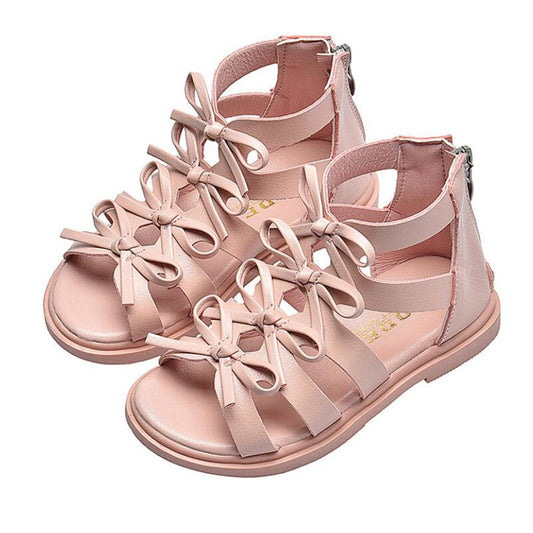 Pink sandals with bow details on a white background
