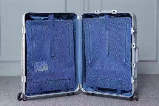 Open silver suitcase with blue interior on a gray background