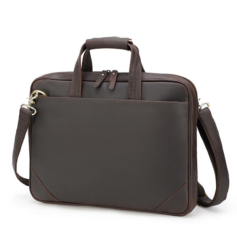 Brown leather briefcase with shoulder strap on a white background