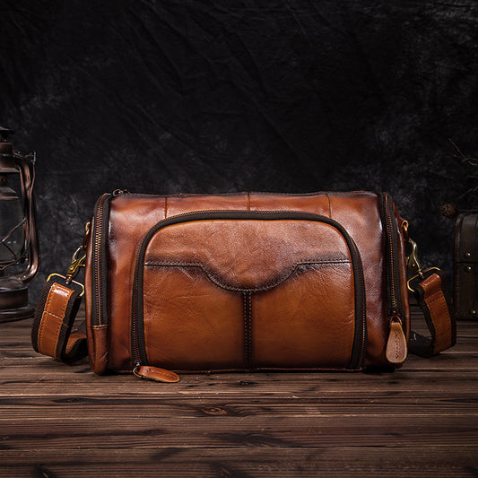 Brown leather bag on a wooden surface with a dark background