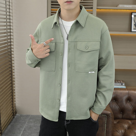 Person wearing a green jacket indoors with a blurred background