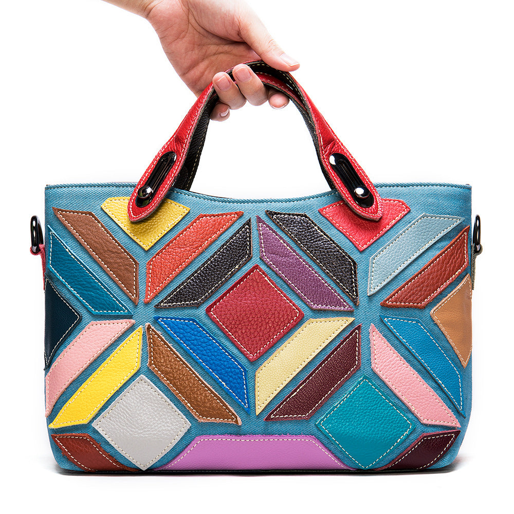 Colorful geometric-patterned handbag held by a hand on a white background