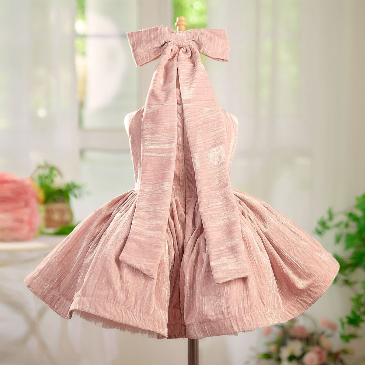 Pink dress on a mannequin with a blurred indoor background