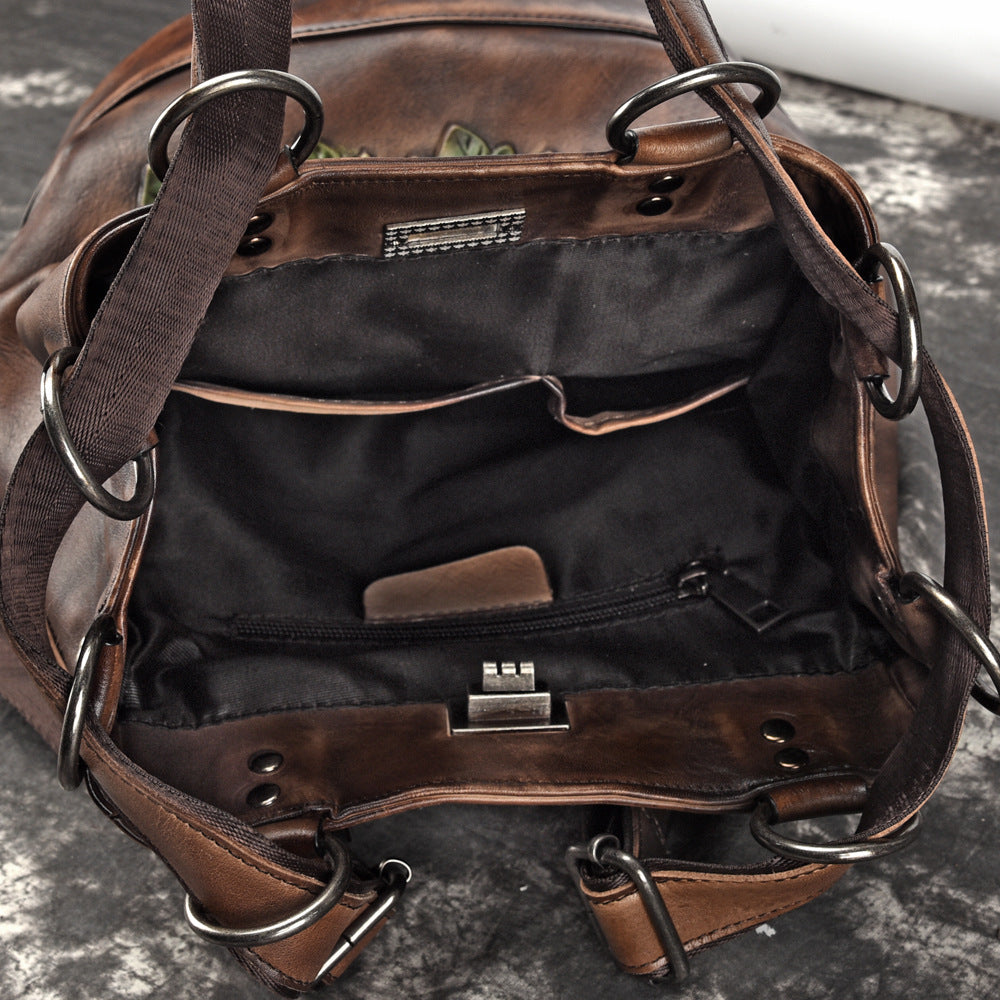 Brown leather bag with visible stitching on a dark surface
