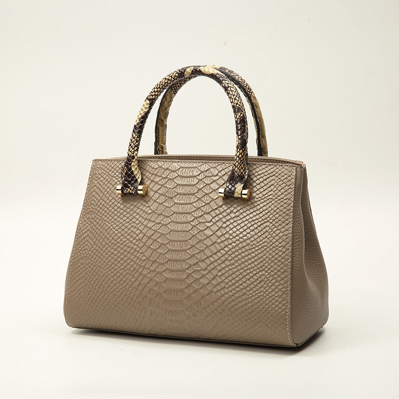 Beige handbag with snake skin pattern on a light background