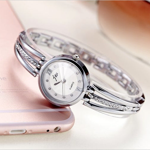 Silver bracelet watch with diamond accents on a light background