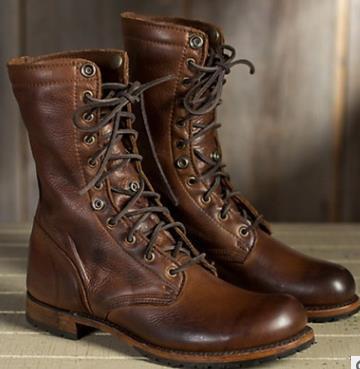 Pair of brown leather boots with lace-up design on a wooden surface.