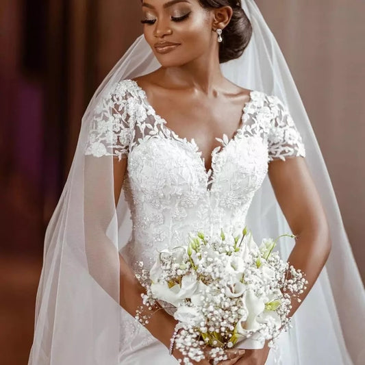 Bride in a white wedding dress holding a bouquet with a blurred background