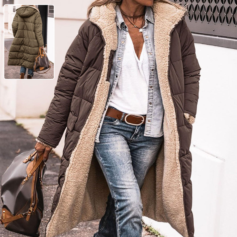 Person wearing a long brown puffer coat with beige lining, holding a gray bag.