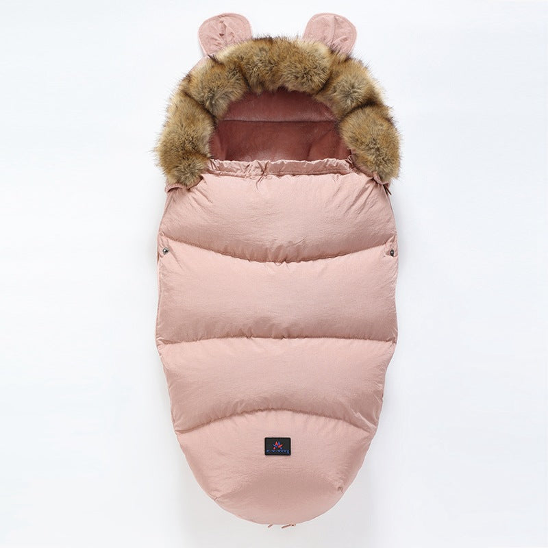 Pink baby sleeping bag with fur hood on a white background