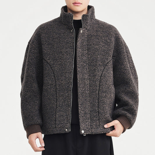 Person wearing a gray textured jacket on a light gray background