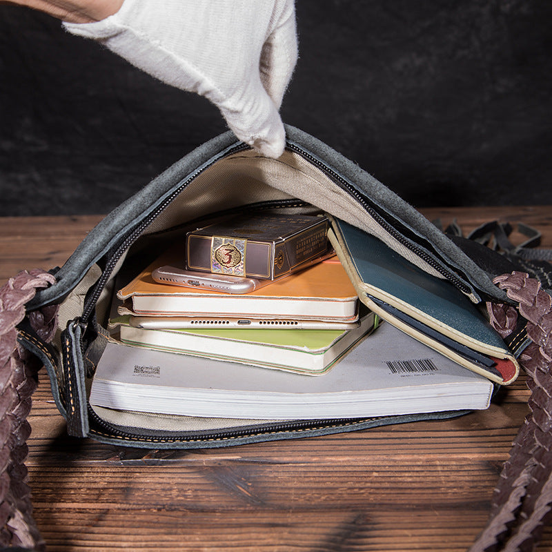 Open bag with notebooks and a clock on a wooden surface