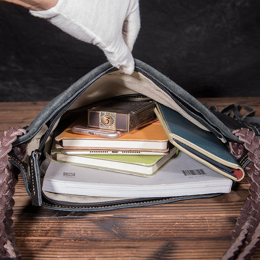 Open bag with notebooks and a clock on a wooden surface