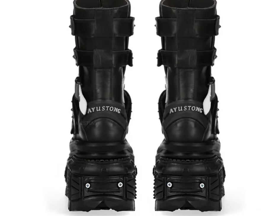 Pair of black high-heeled boots with unique design on a white background