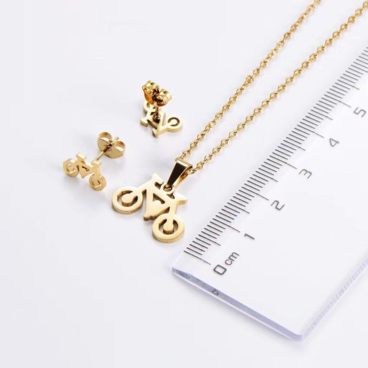 Gold necklace and earrings with a ruler for scale on a white background