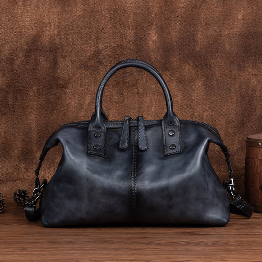 Black leather handbag on a wooden surface with a brown textured background