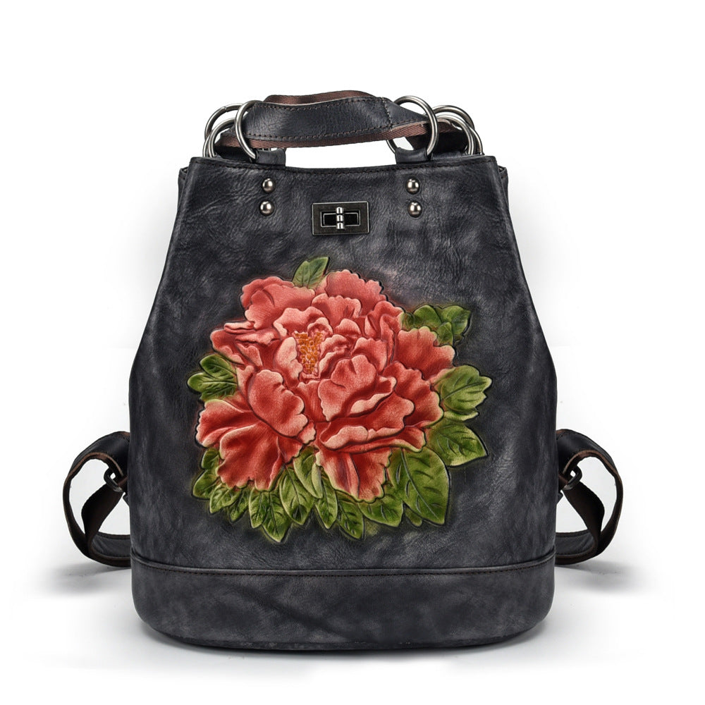 Black backpack with a large pink floral design on a white background