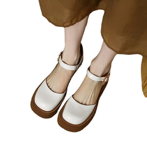 White and brown shoes worn by a person on a white background
