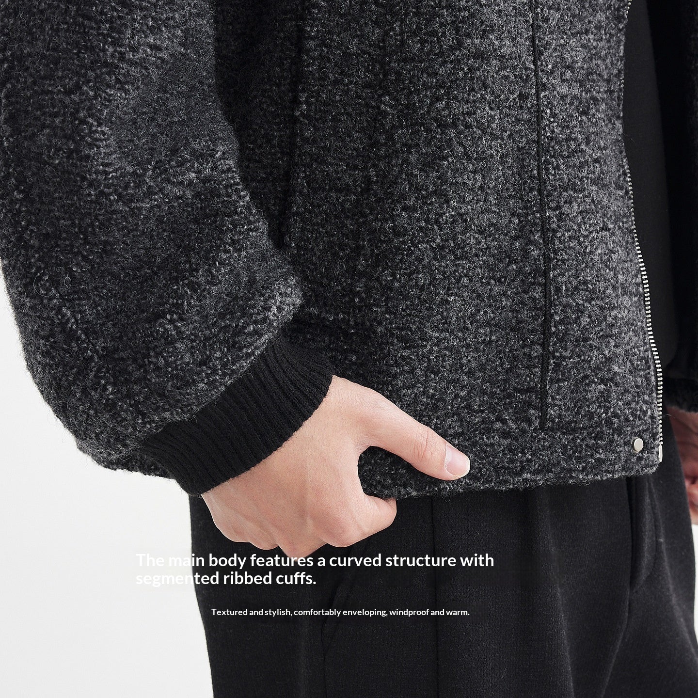 Close-up of a dark gray textured jacket with ribbed cuffs on a white background