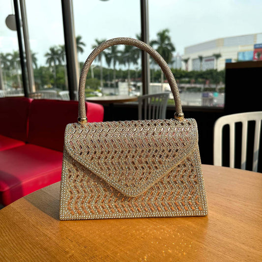 Gold beaded handbag on a wooden table with a blurred background