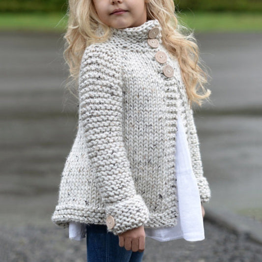 Child wearing a knitted sweater with buttons outdoors