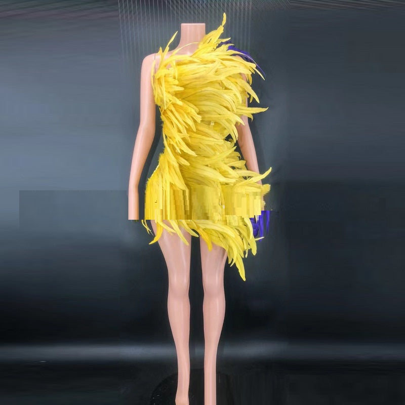 Yellow feathered dress on a mannequin against a dark background