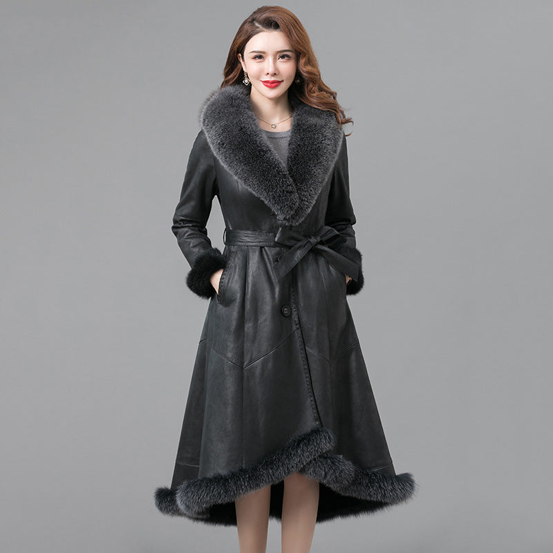Woman wearing a black coat with fur trim on a gray background