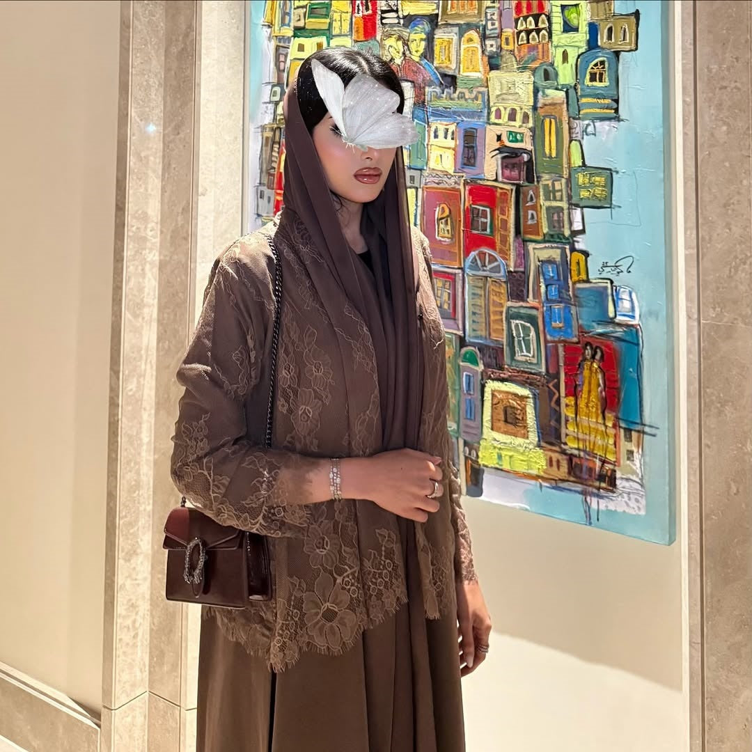 Woman in a brown outfit standing in front of a colorful painting