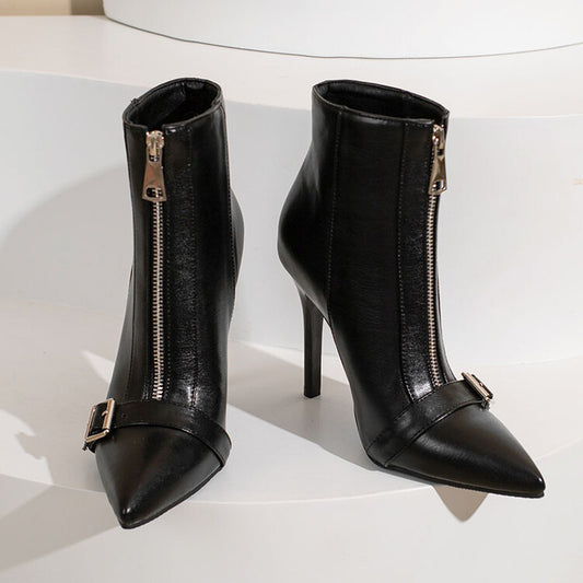 Pair of black high-heeled ankle boots with gold zippers on a white background
