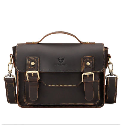 A dark brown leather messenger bag with a top handle, dual buckle straps on the front, and a detachable shoulder strap, shown against a plain white background.