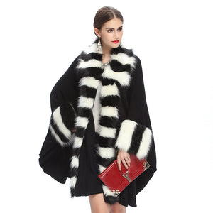 Woman wearing a black and white striped fur coat with a red clutch on a white background