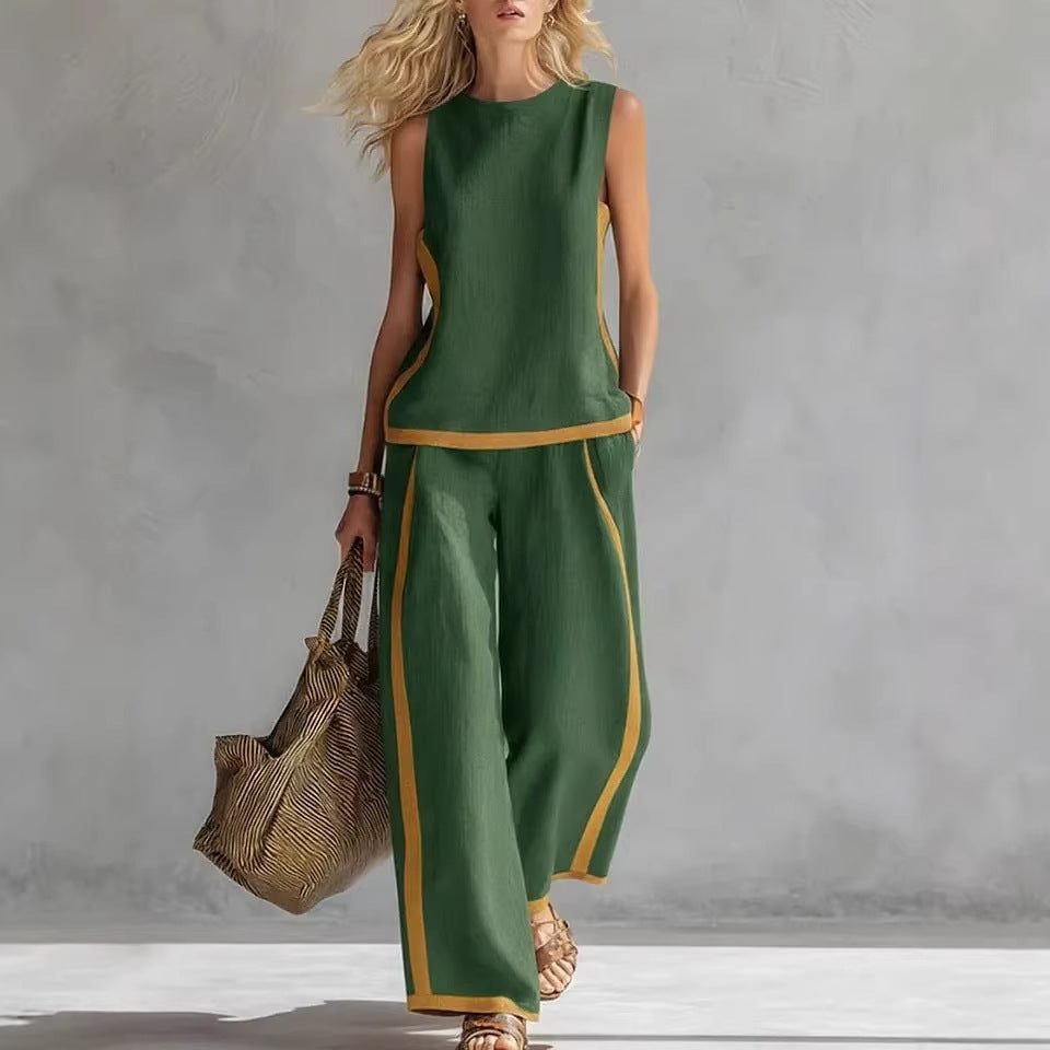 Woman wearing a green outfit with gold trim holding a woven bag against a gray background