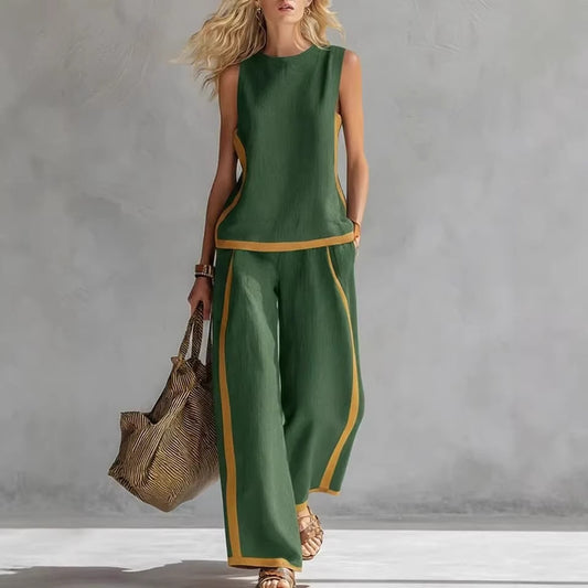 Woman wearing a green outfit with gold trim holding a woven bag against a gray background