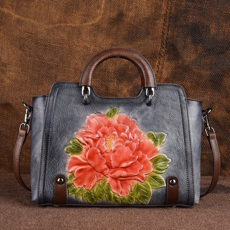 Gray handbag with a large floral design on a brown background