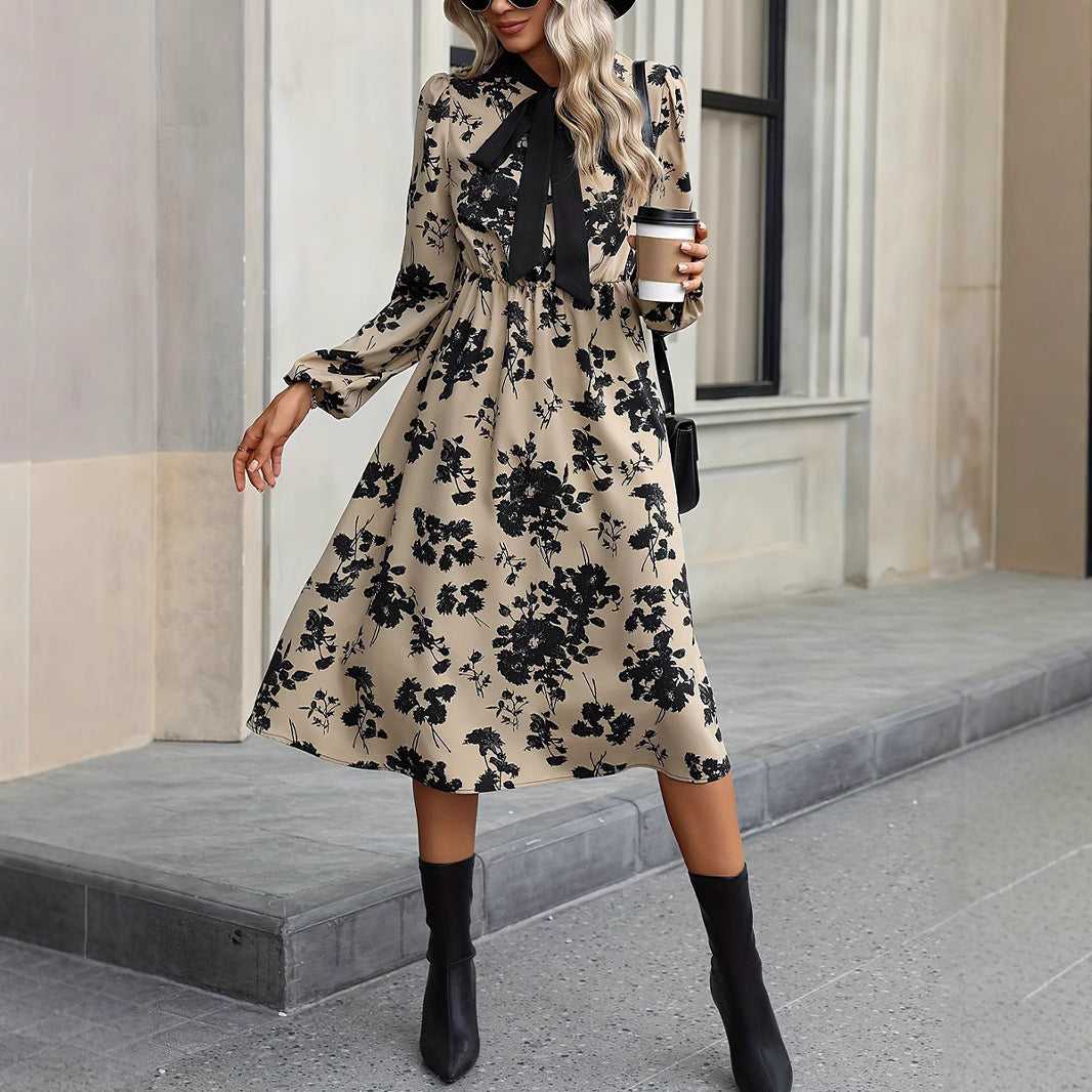 Woman in a floral dress holding a coffee cup on a city street.