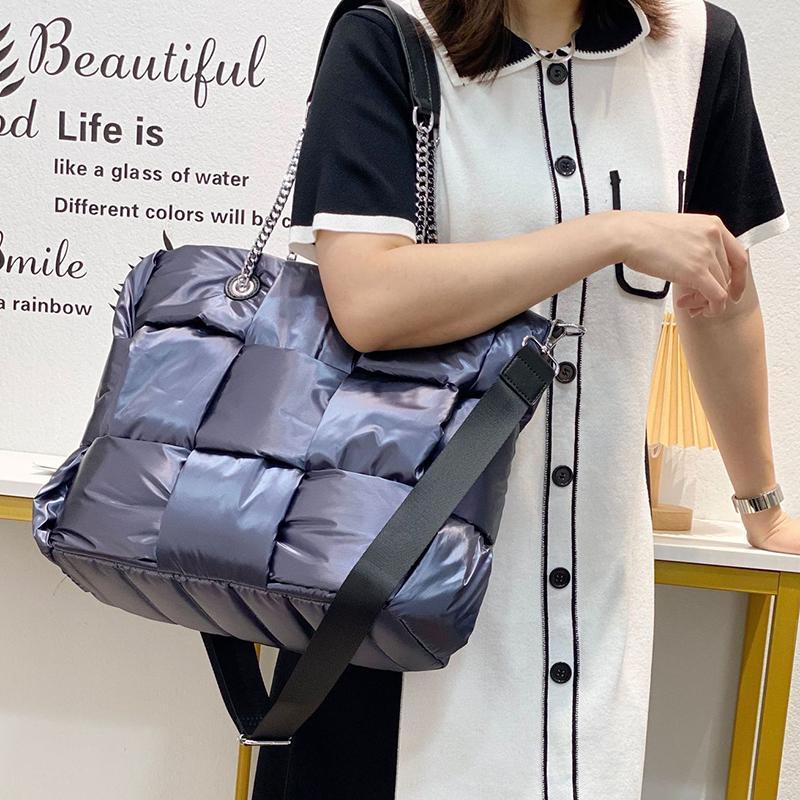 Person holding a blue quilted bag with a white background