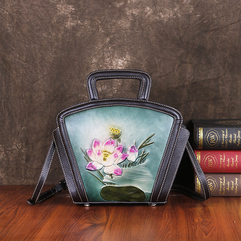 Handbag with floral design on a wooden surface and textured brown background