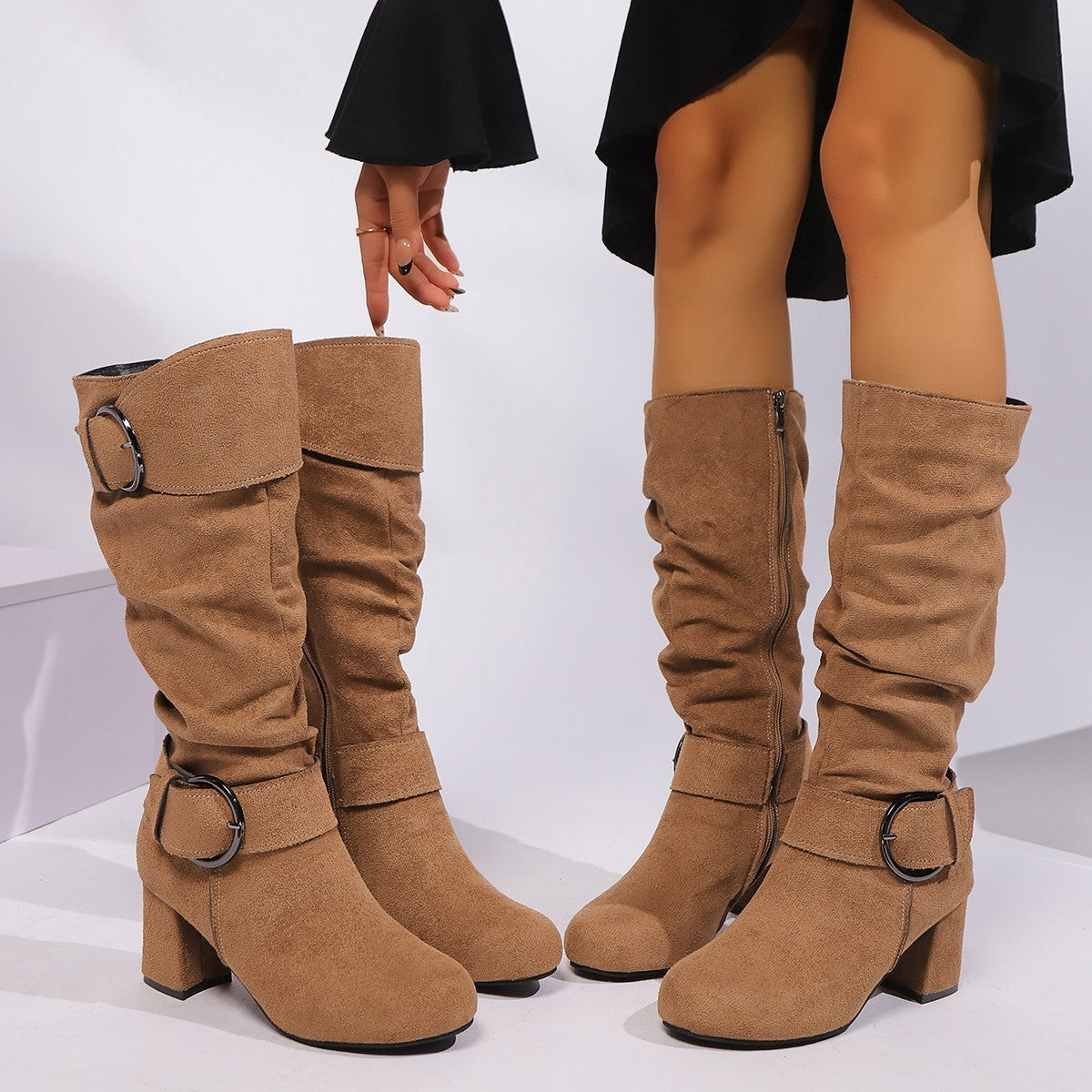 Tan knee-high boots with buckles on a white background