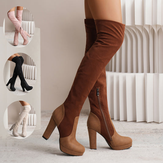 Brown knee-high boots with a platform sole on a neutral background