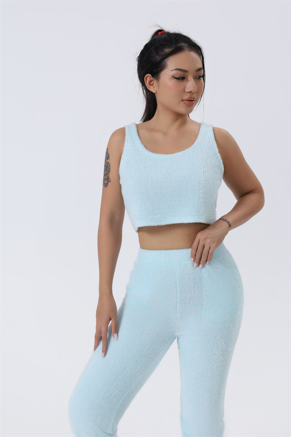 Woman wearing a light blue athletic outfit on a white background