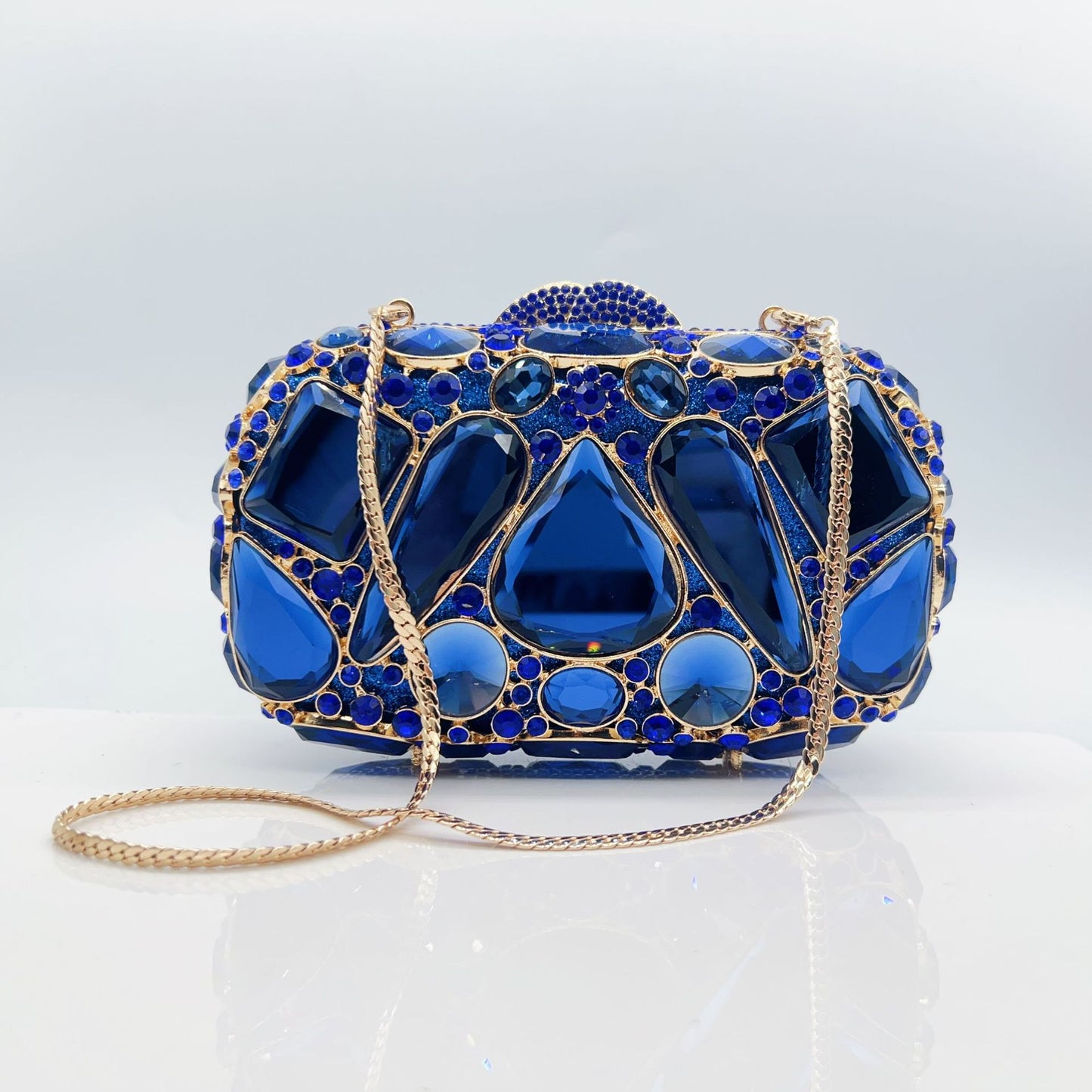 Blue evening bag with gold accents on a light gray background