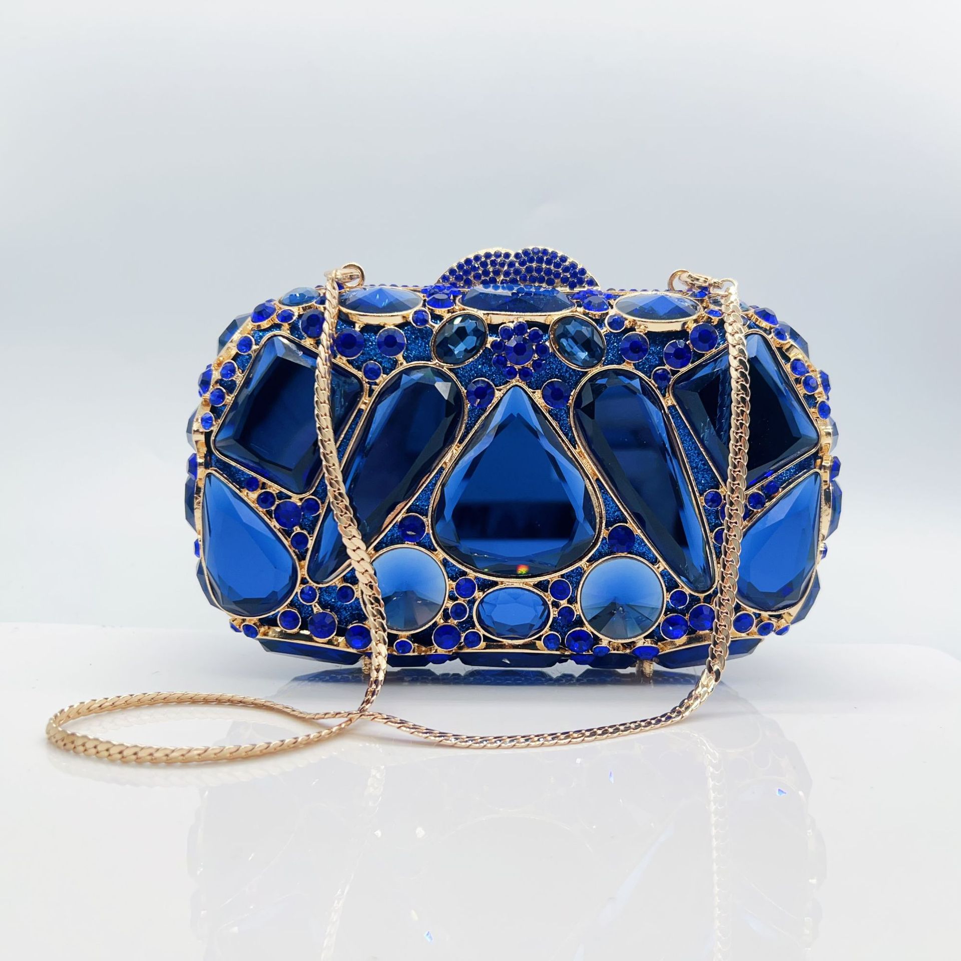 Blue evening bag with gold accents on a light gray background