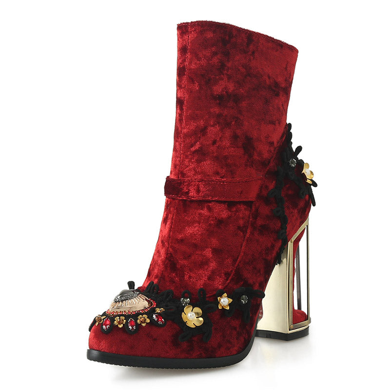 Red velvet boot with decorative elements on a white background