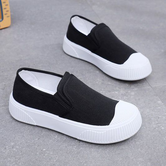 Black and white slip-on shoes on a gray surface