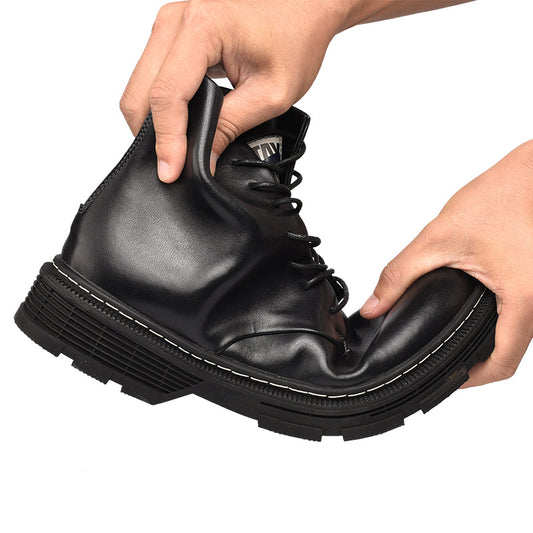 Black leather boot with a thick sole held by two hands on a white background
